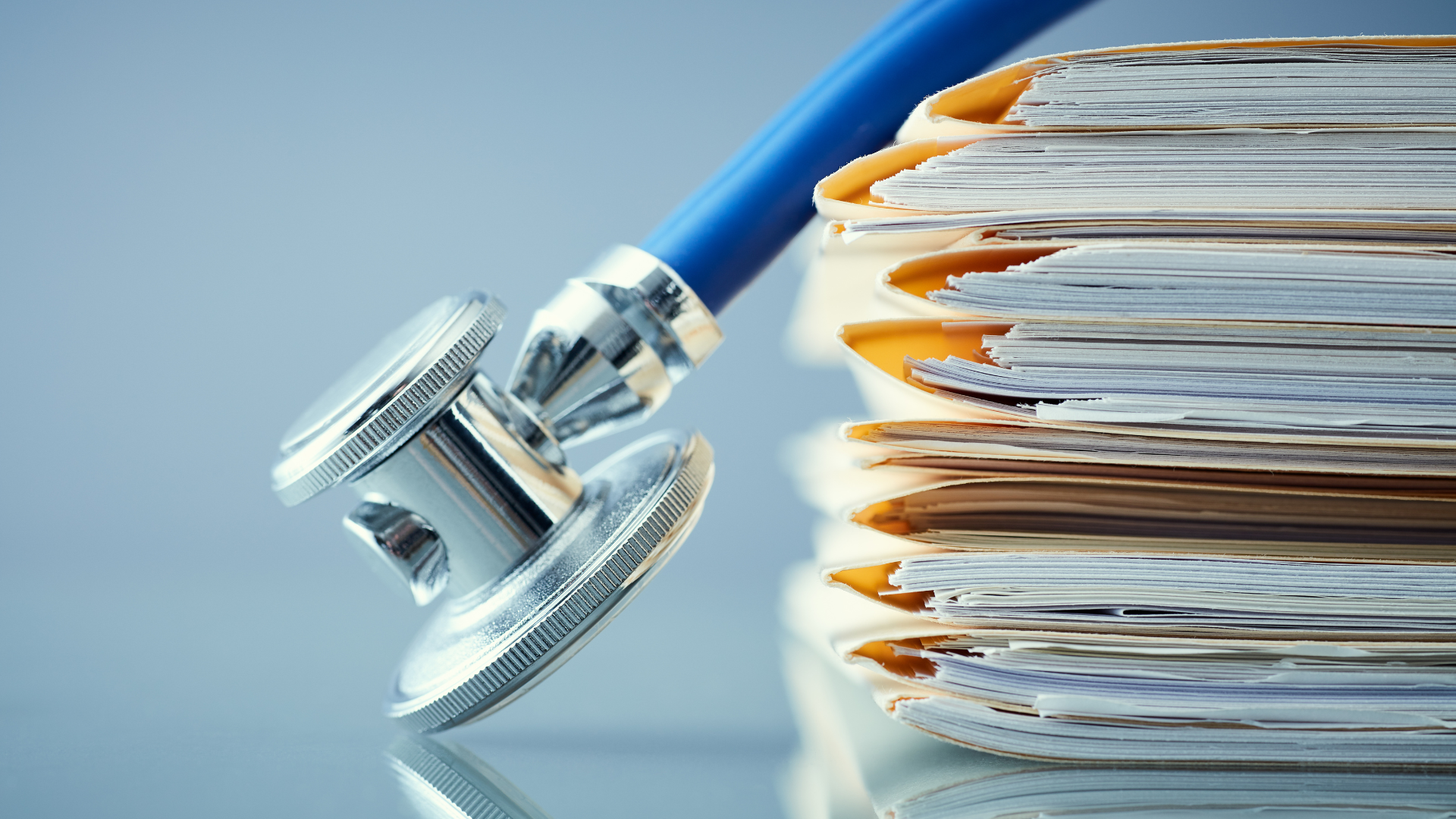 Stethoscope resting on a stack of medical files