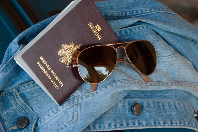 Passport and sunglasses on a denim jacket