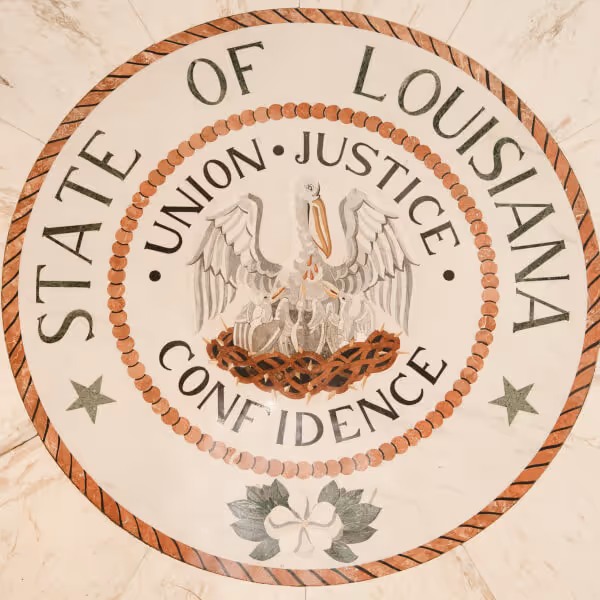Seal of the State of Louisiana featuring a pelican with three chicks in a nest surrounded by the words Union, Justice, Confidence.