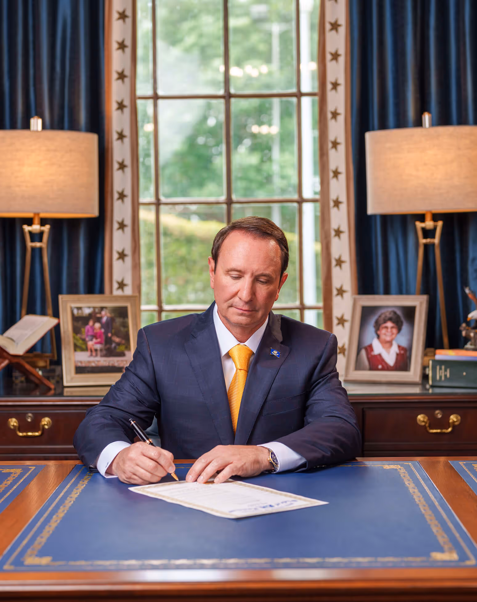 Gov. Jeff Landry signing paperwork at Mansion desk