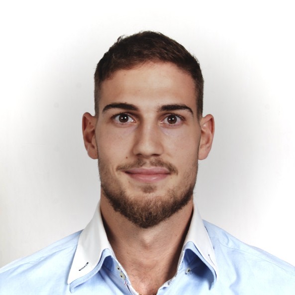 Headshot of a young man with short brown hair, a trimmed beard, and brown eyes, wearing a light blue collared shirt.