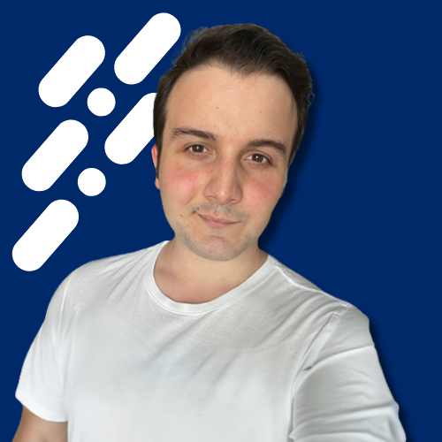 Young man with short dark hair wearing a white t-shirt against a blue background with white diagonal dash patterns.