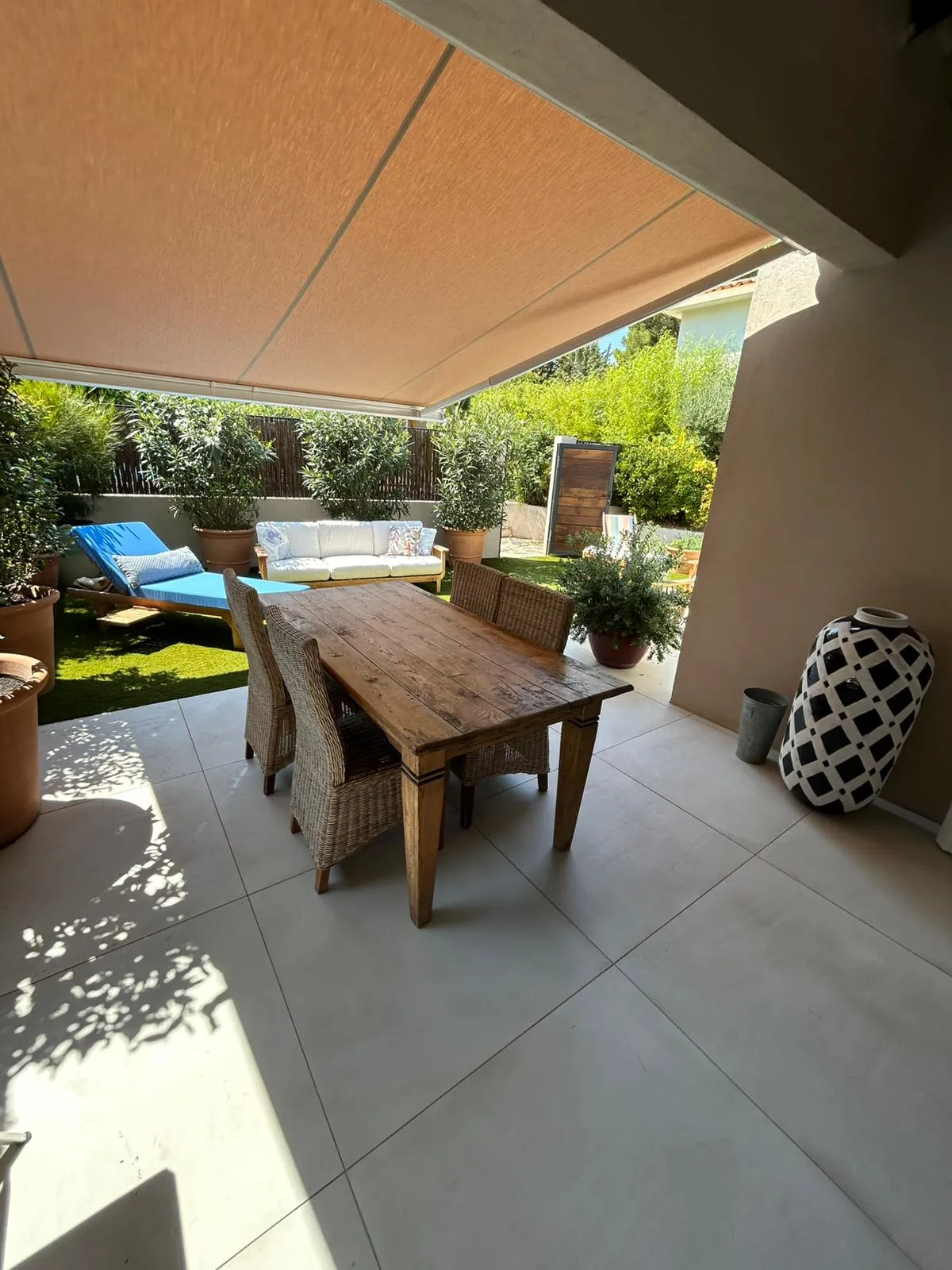 Grande terrasse couverte avec table à manger et jardin de 90 m².