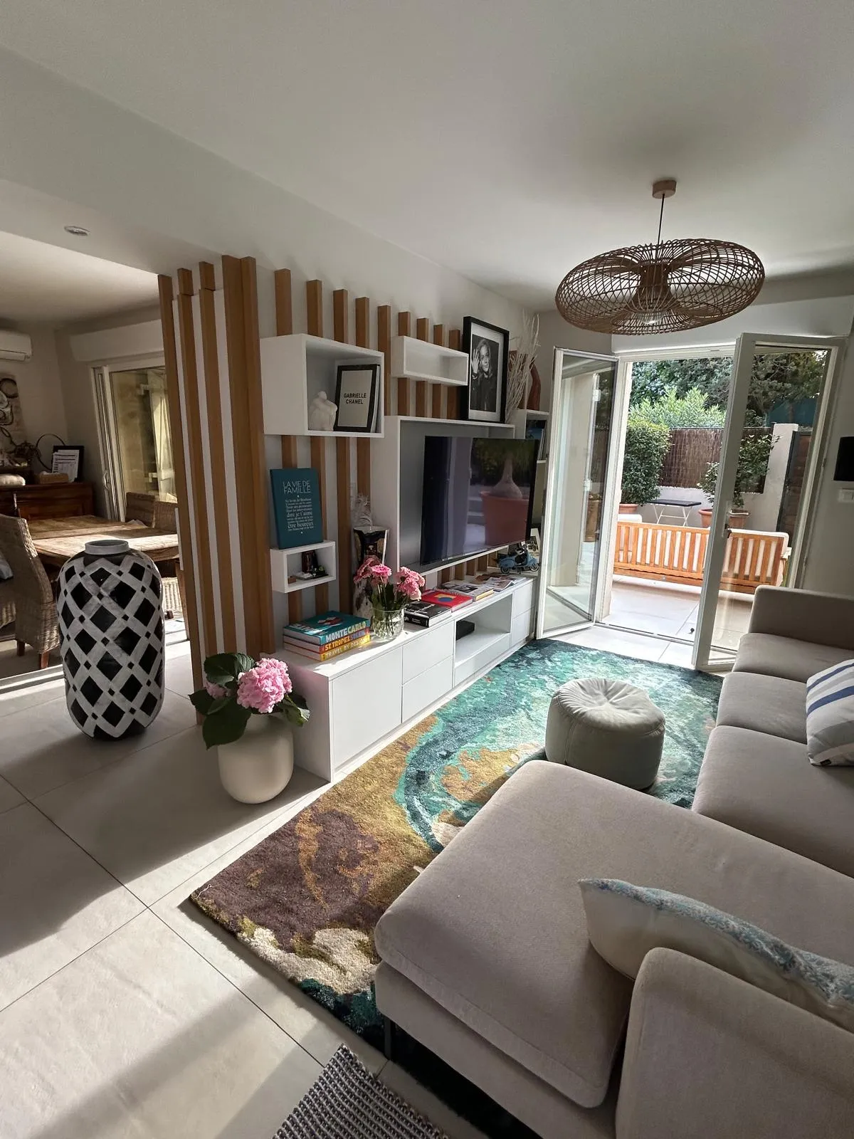 Grand séjour de 42.5 m² avec coin télévision, salle à manger et cuisine ouverte.