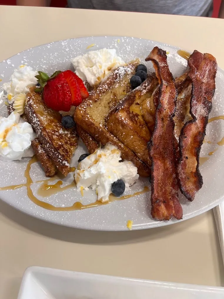 A plate featuring golden French toast, crispy bacon, and fresh blueberries arranged appetizingly.