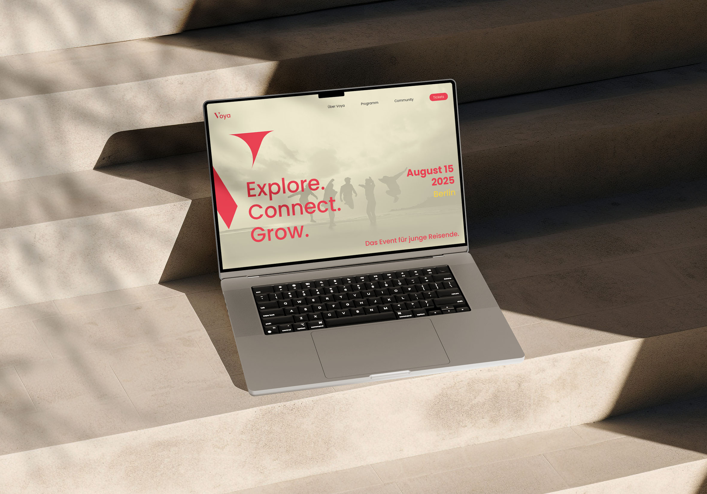 Open laptop on stone steps displaying a website with the text 'Explore. Connect. Grow.', event date August 15, 2025, Berlin.