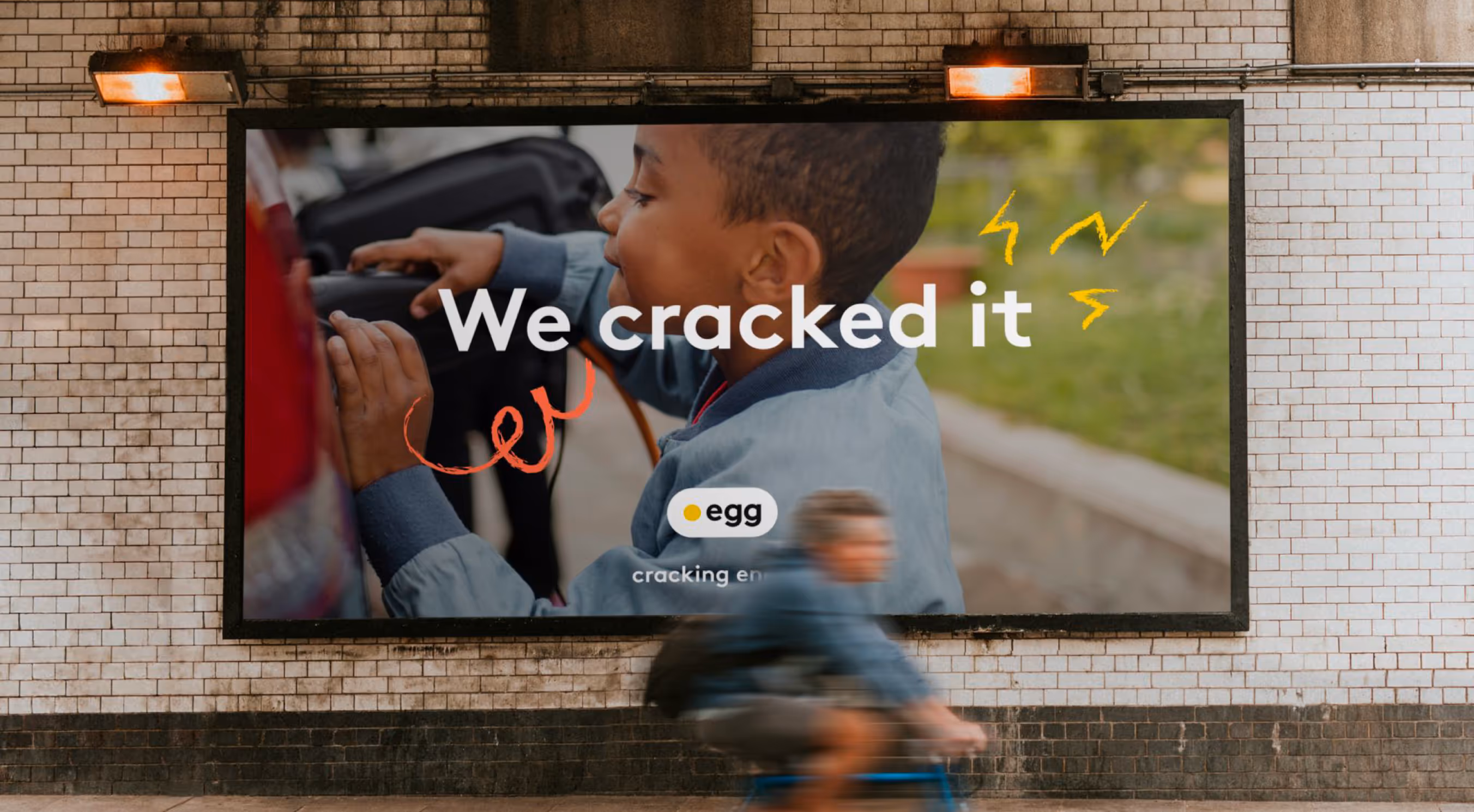 Billboard featuring a close-up of a child smiling and touching an object with text 'We cracked it' and an egg logo.