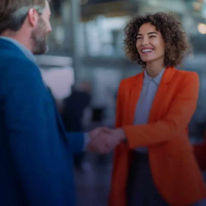 Two business professionals shaking hands in an office setting