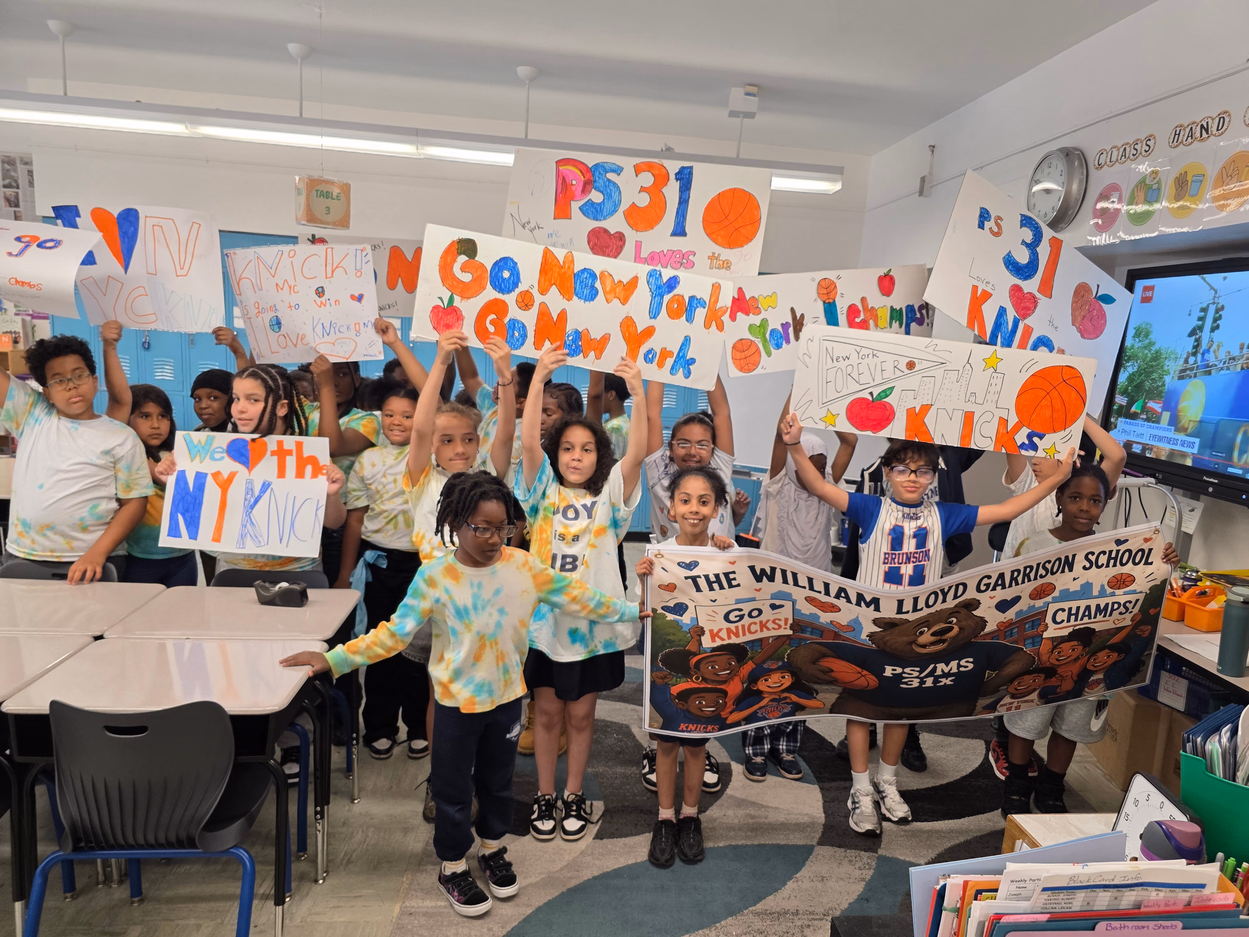PS 31 students holding handmade Go Knicks signs in classroom