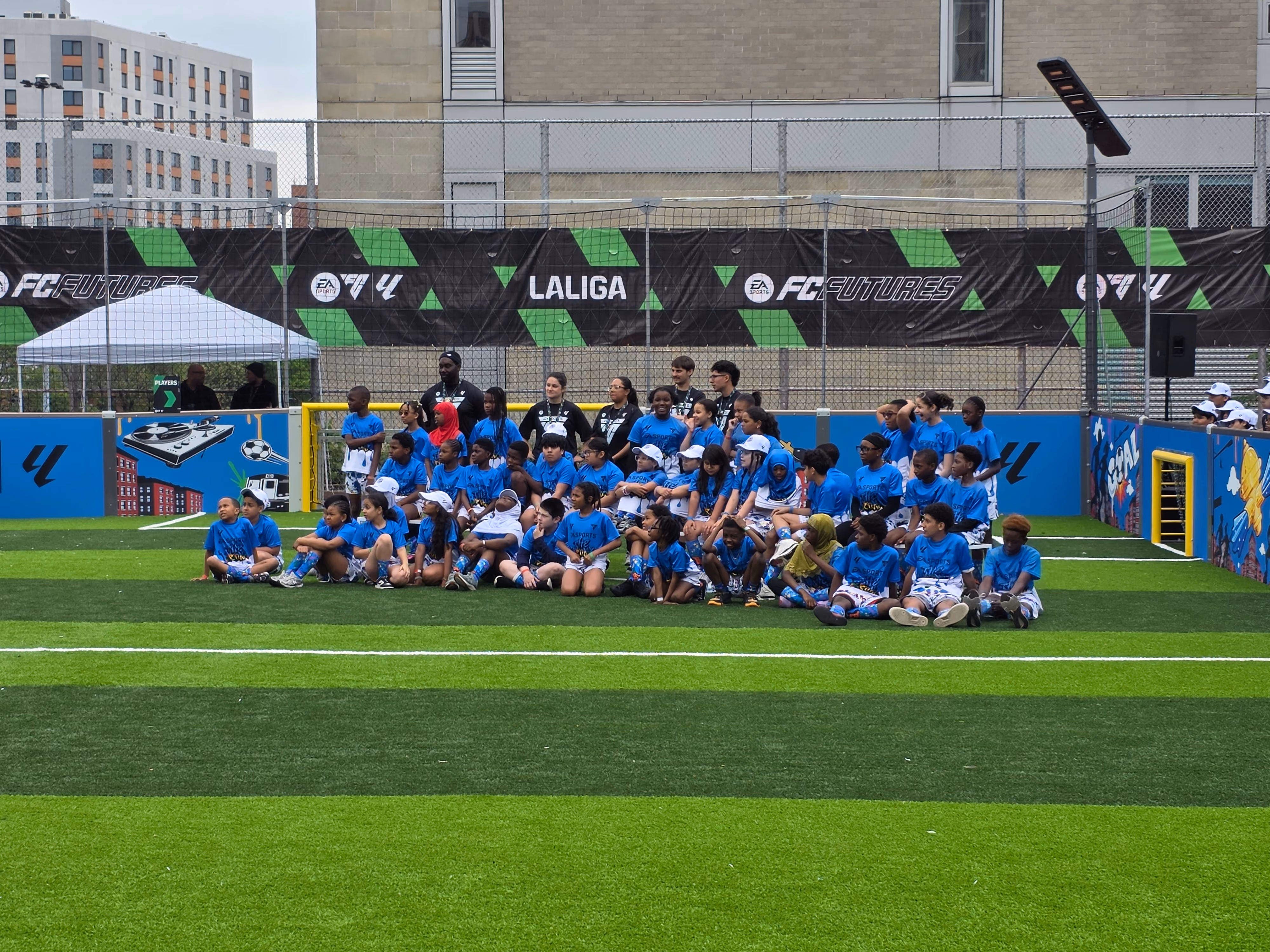 Students and coaches pose on soccer field at EA FC Futures Laliga event