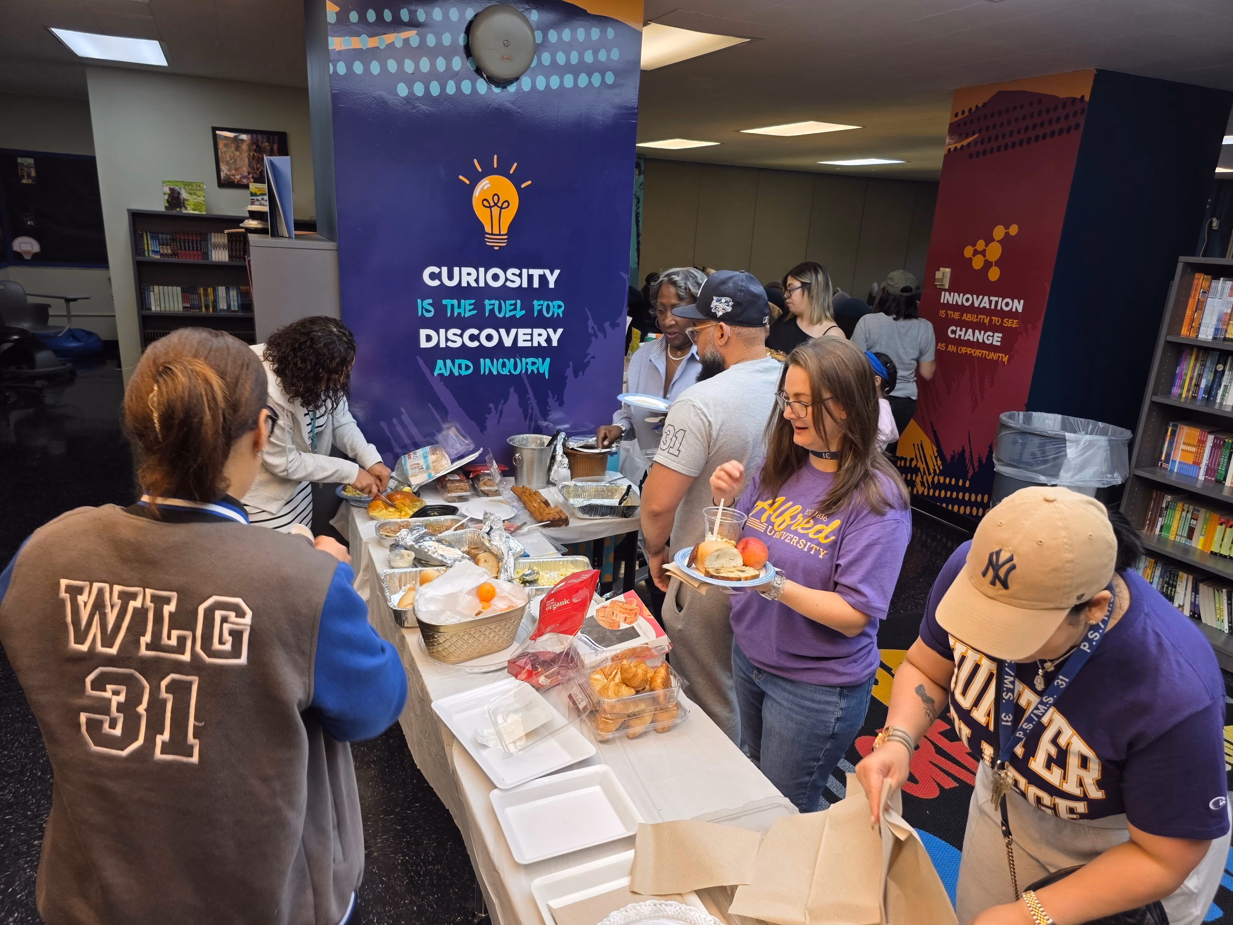Staff and students serving food at a school community breakfast event