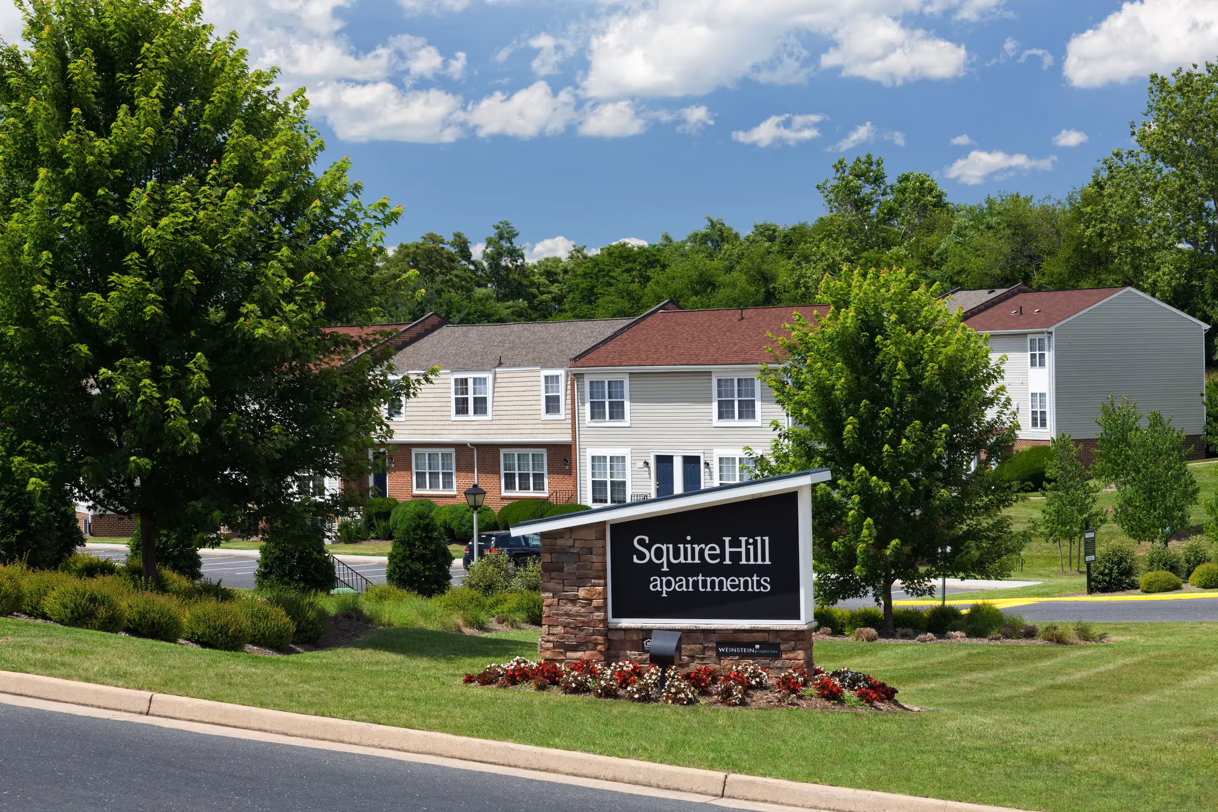 Squire Hill exterior logo sign with view of exterior leasing office