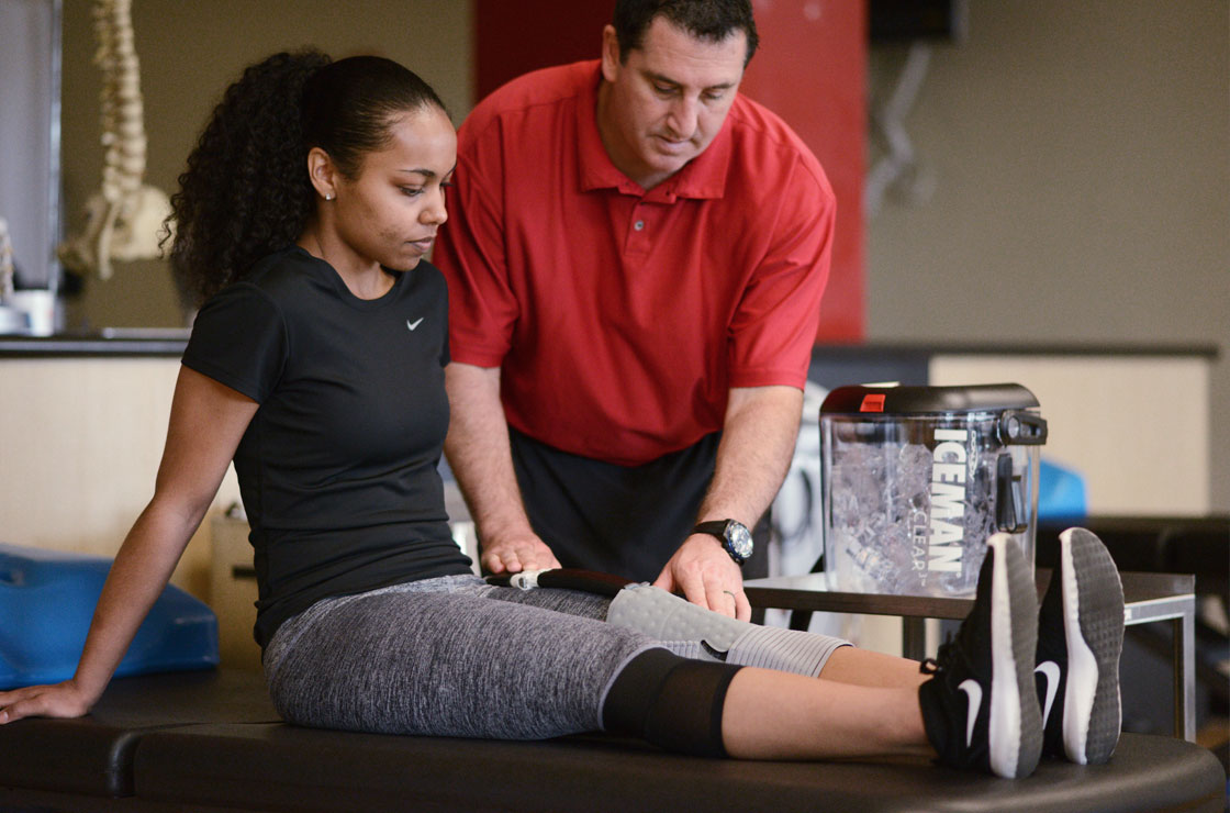 Athletic Trainer applying DonJoy Iceman Clear to a woman's knee.