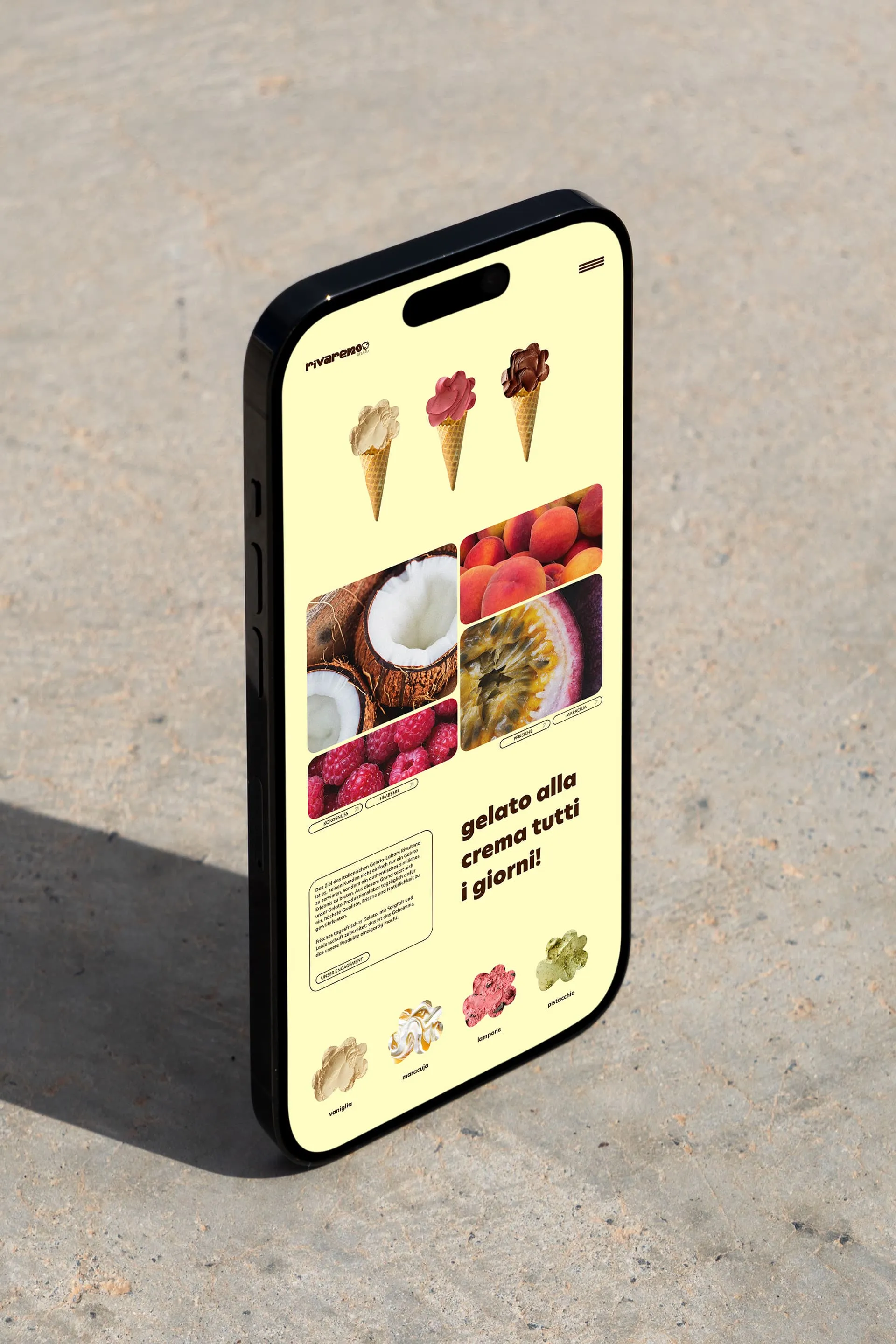 Smartphone mit geöffneter Webseite, die verschiedene Eissorten und Früchte wie Kokosnuss, Himbeeren, Pfirsich und Maracuja zeigt, mit dem Text 'gelato alla crema tutti i giorni!'