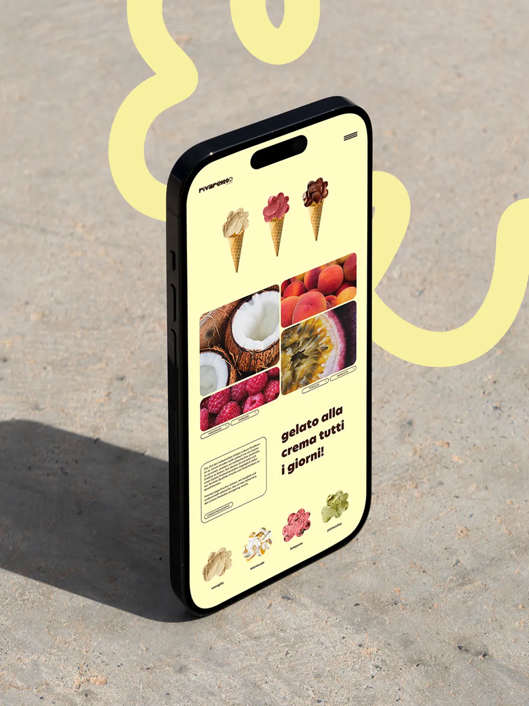 Smartphone zeigt gelbe Webseite mit Eiscreme-Kugel-Icons und Bildern von Früchten auf grauem Untergrund.