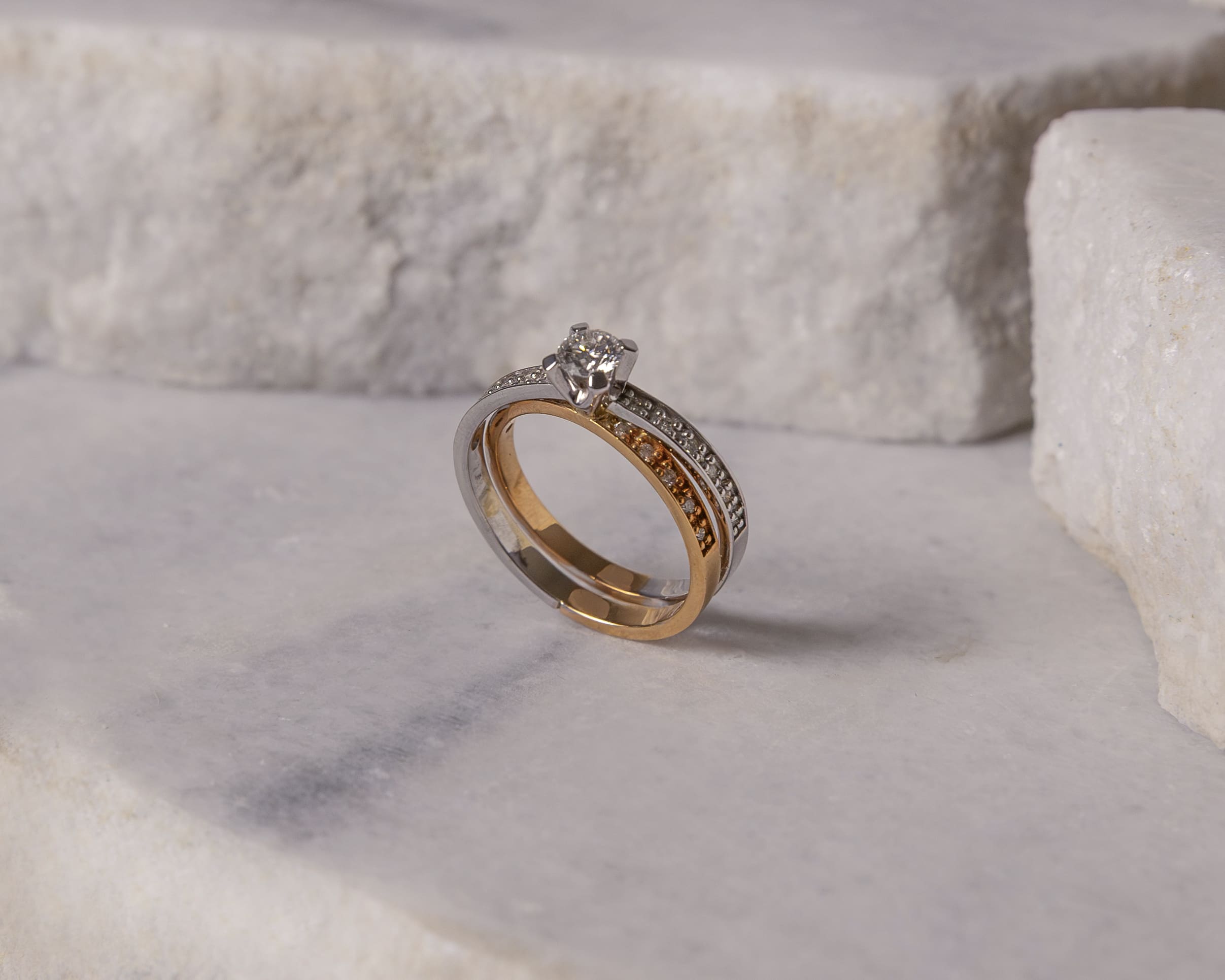 Two-tone gold and silver engagement ring with a central diamond and pavé-set small diamonds.