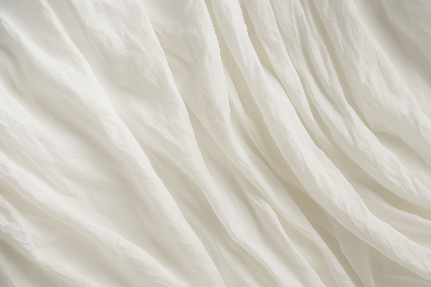 Tessuto bianco morbido con pieghe e texture ondulata.