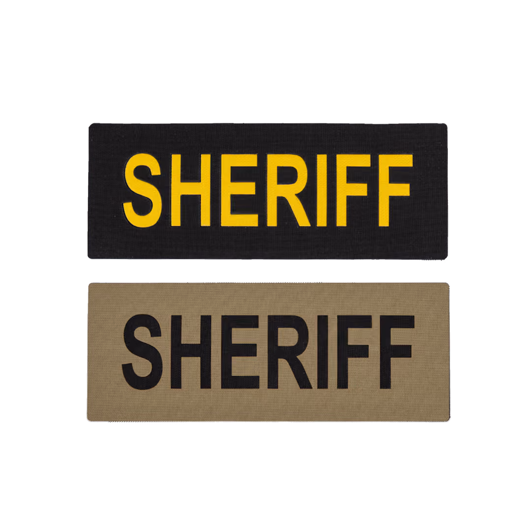 Two sheriff cloth patches; one black with yellow text, one tan with black text.
