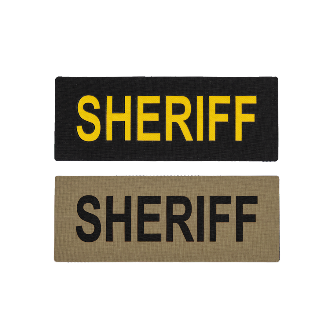 Two sheriff cloth patches; one black with yellow text, one tan with black text.