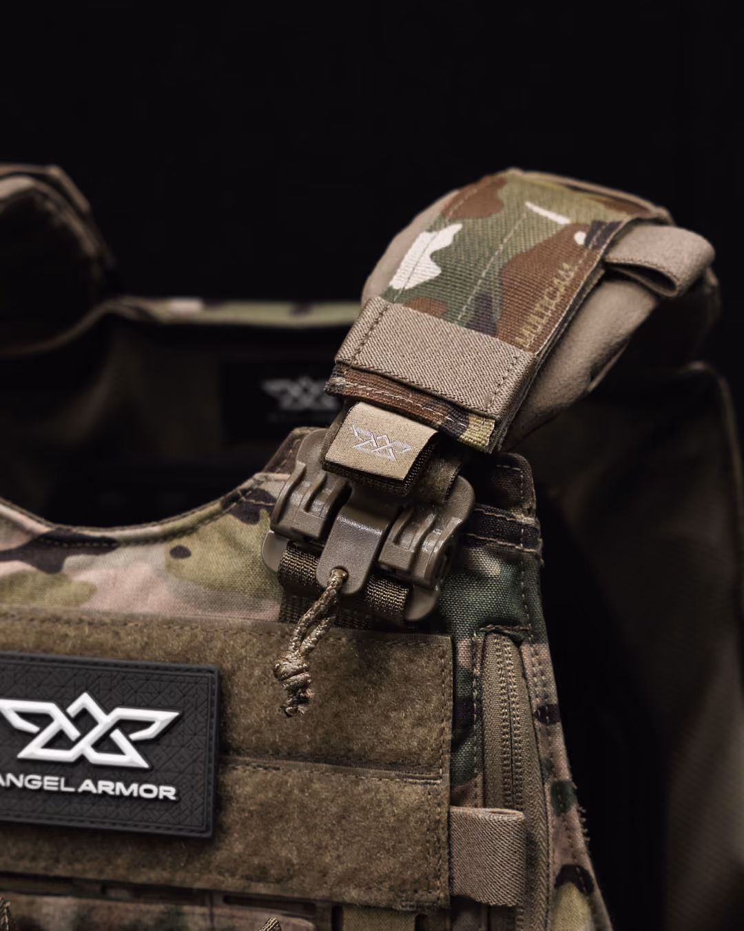Close-up of camo tactical vest shoulder strap with buckle and Angel Armor patch.