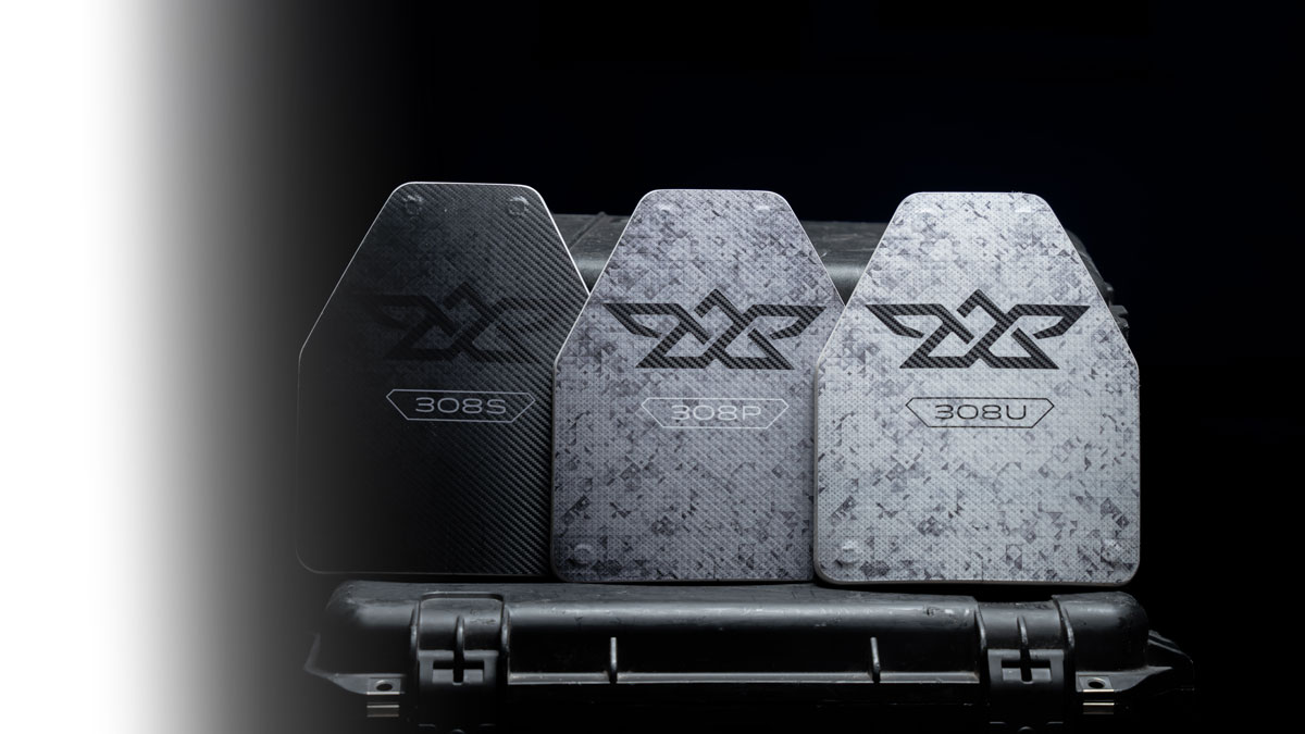 Three ballistic plates labeled 308S, 308P, 308U resting on a hard case against a black background.