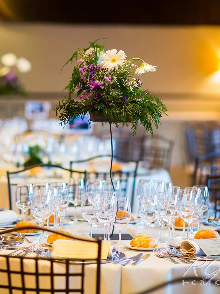 Pareja de recién casados sonrientes sentados en un coche antiguo blanco descapotable con la puerta abierta.