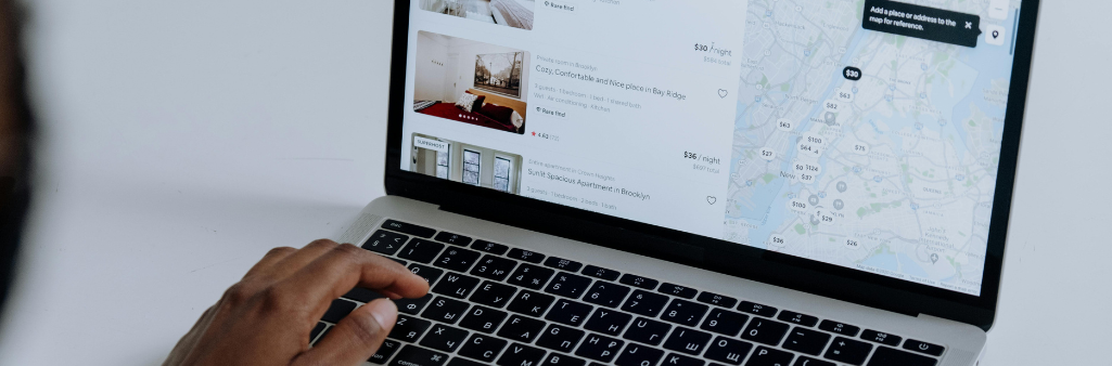 Person browsing rental listings and a map on a laptop screen.
