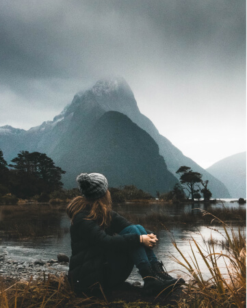 Girl sitting on a background of beautiful mountains