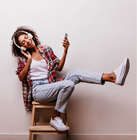 Young happy girl who is energetically listening to music