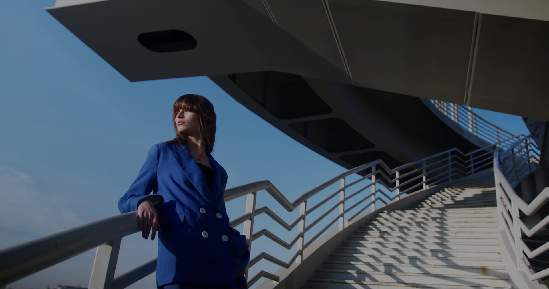 A girl in a blue jacket stands on the stairs