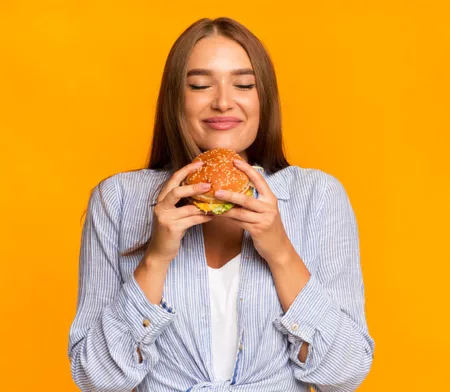 Mujer que sostiene una hamburguesa