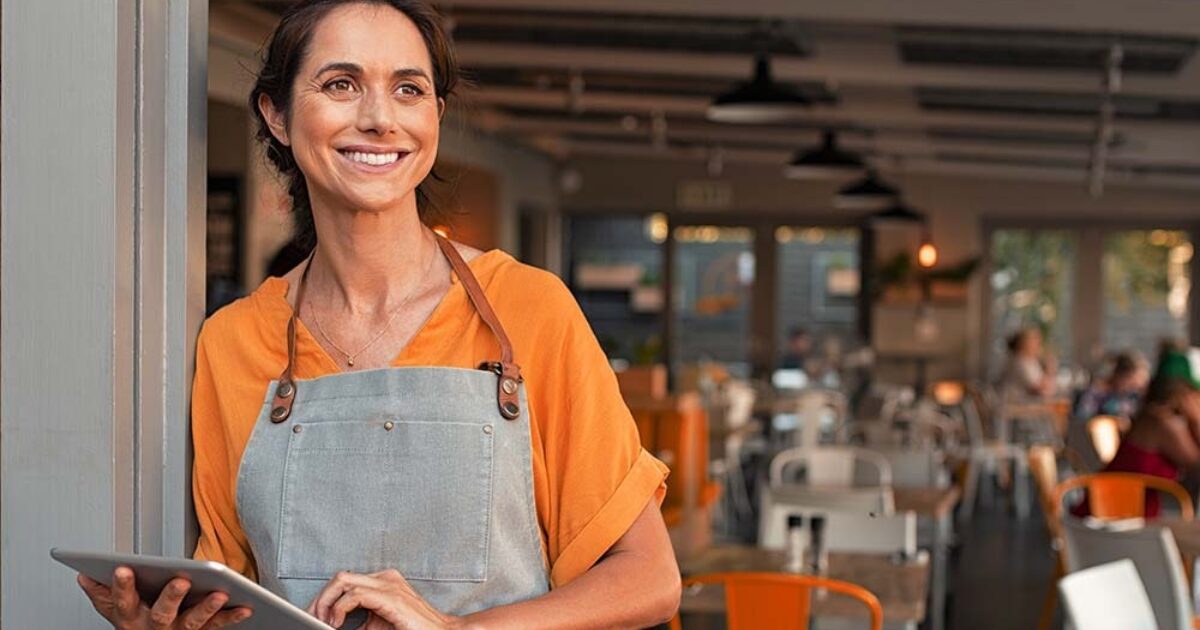 Woman in apron holding tablet