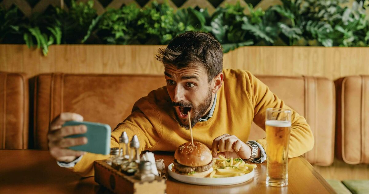 Guy taking a selfie with burger on the plate