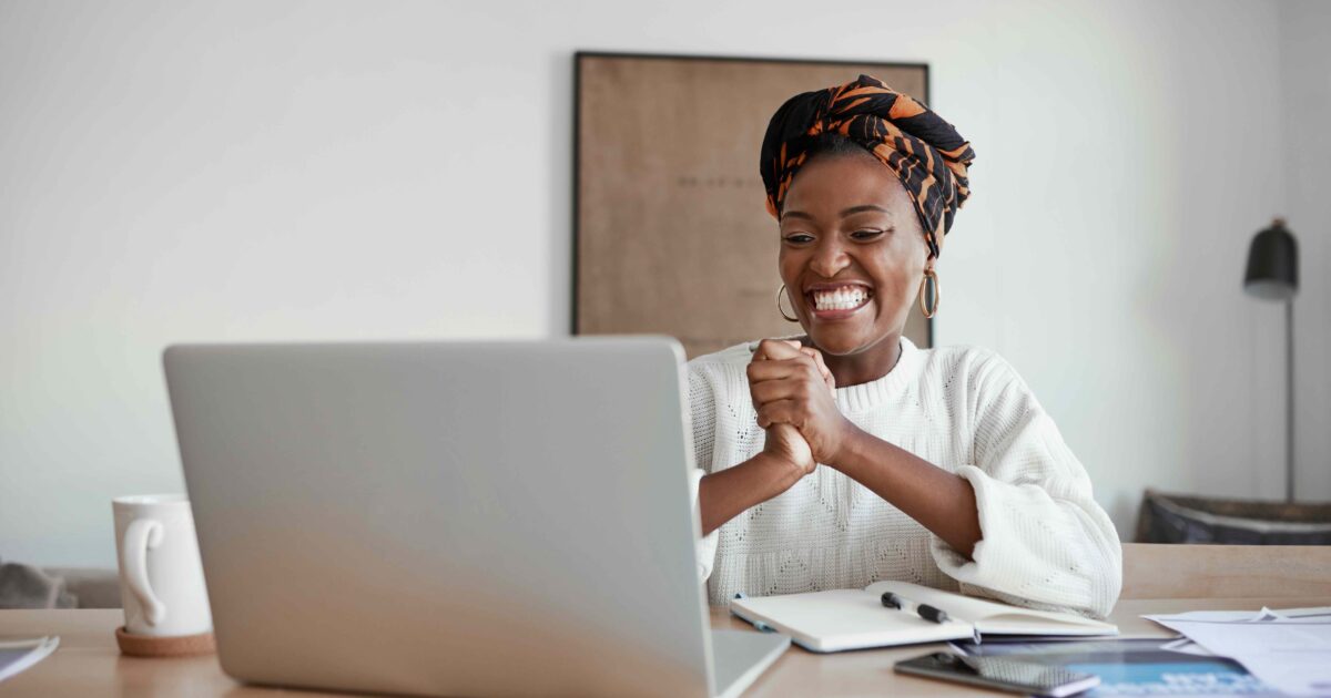 Mujer sonriendo mientras mira su portátil
