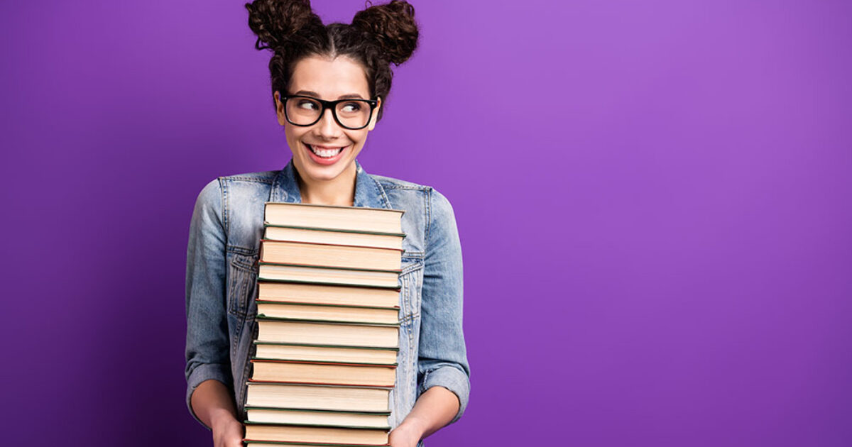 Fille tenant un tas de livres