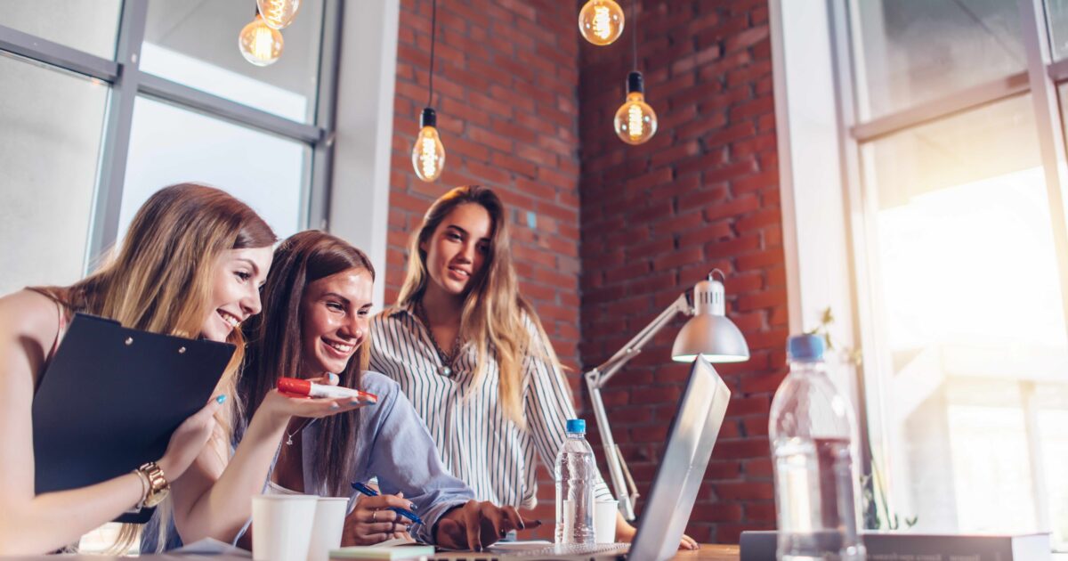Tres mujeres mirando el portátil discutiendo