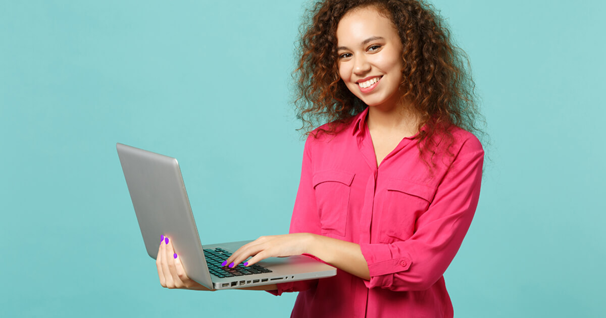 Girl holding laptop and smiling looking at the camera