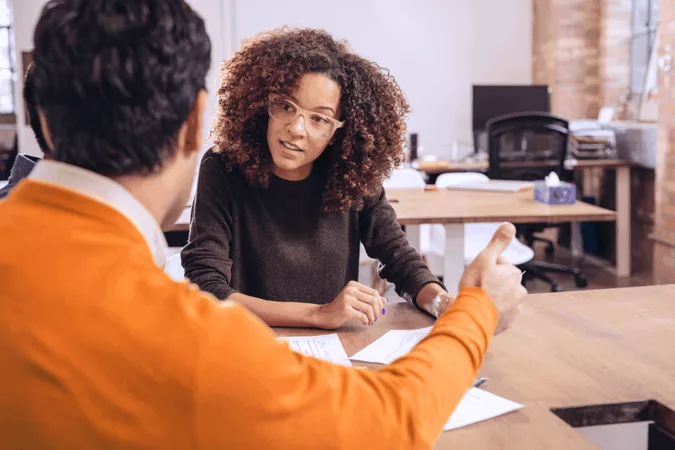 Deux personnes discutent au bureau