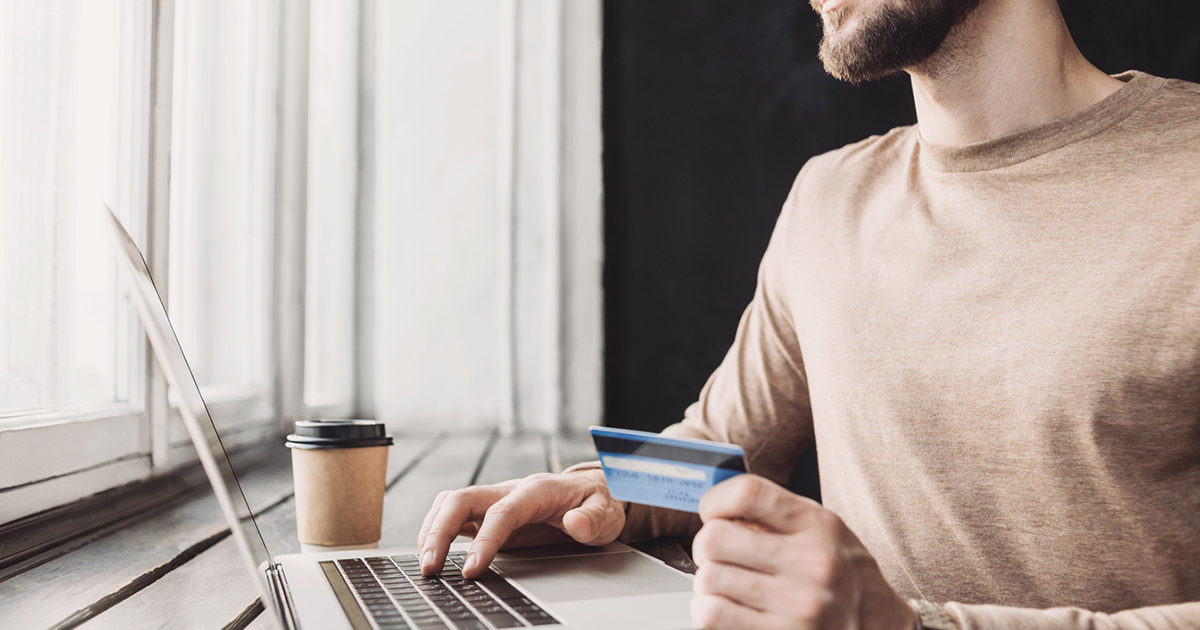 persona que compra en línea con tarjeta de crédito y el portátil