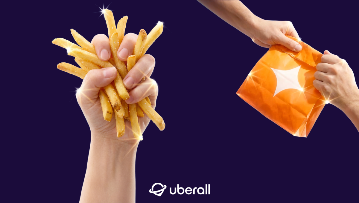 fist holding french fries and fast food bag