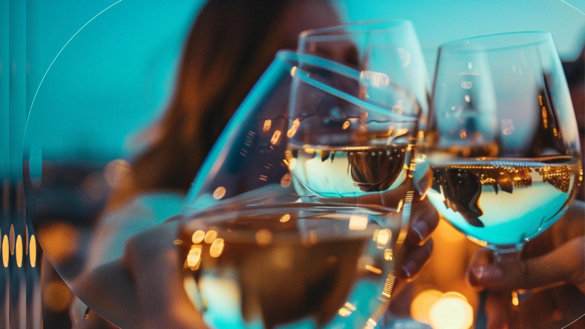 Two glasses of white wine raised in a toast on a restaurant terrace at sunset