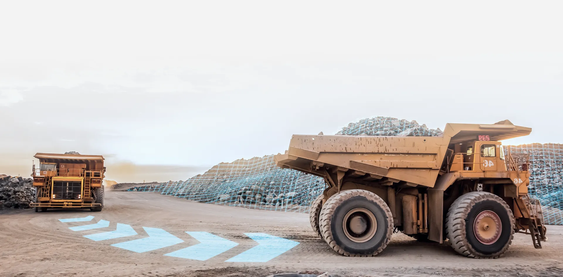 Large mining haul trucks operating at an open-pit mine.