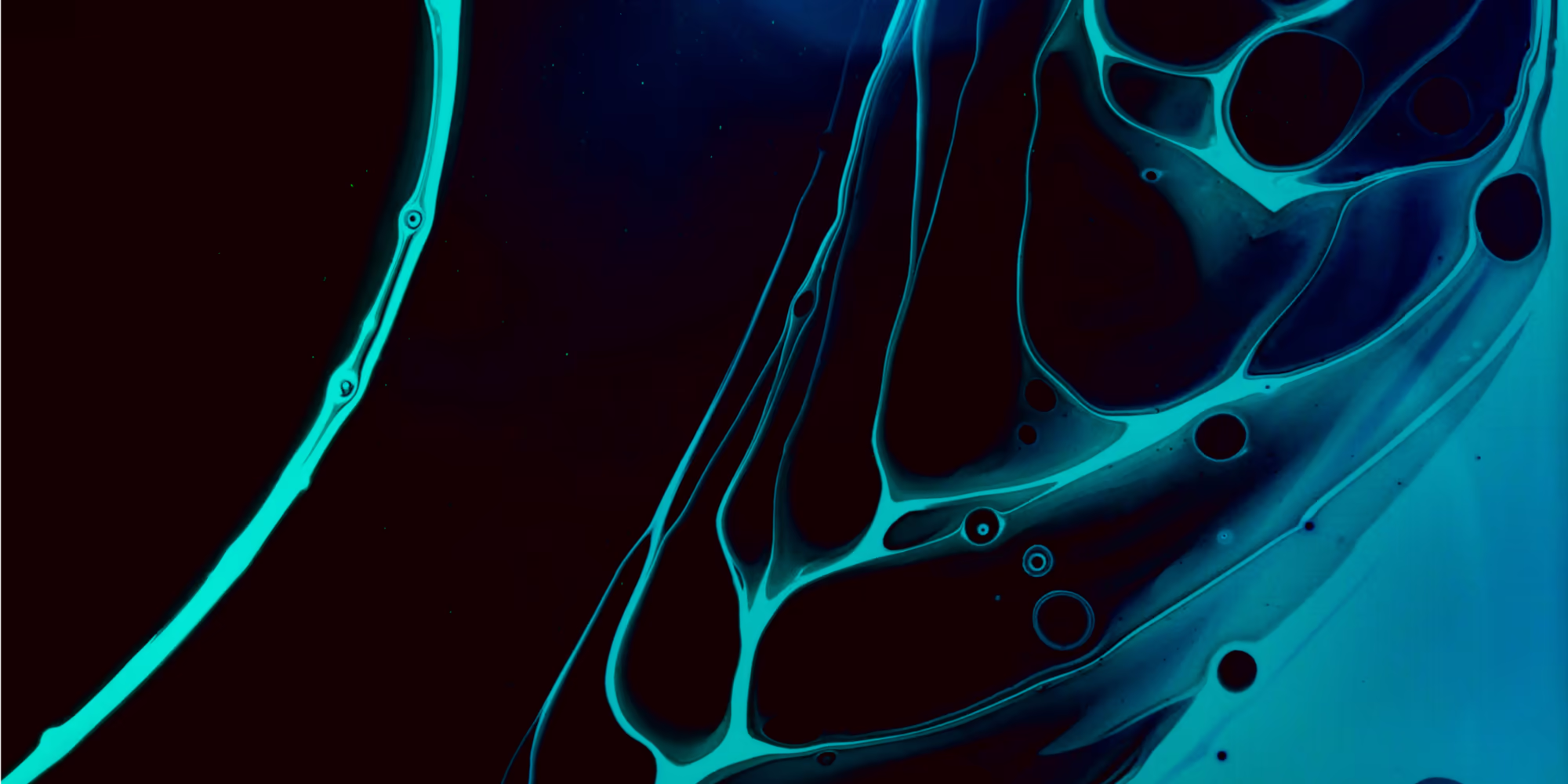 A macro abstract photograph of fluids, creating a texture of cyan & blue oil & water.