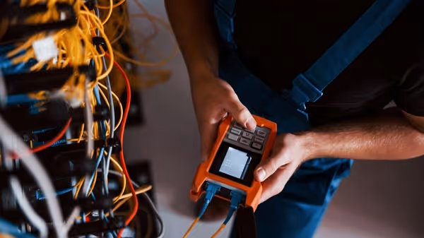 Close-up overhead shot of a technician conducting tests on wiring with a piece of equipment.
