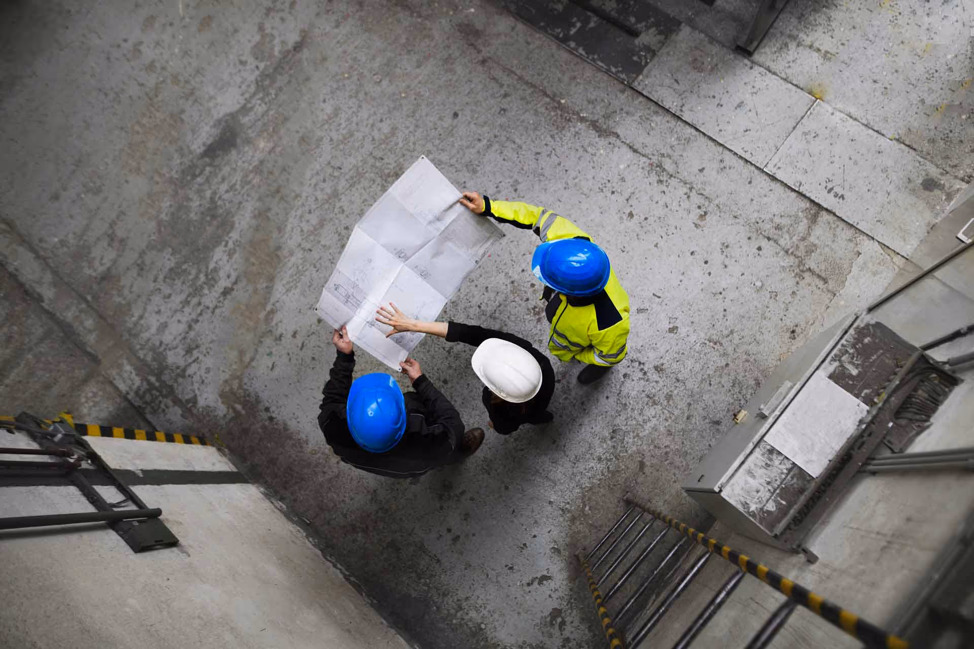 Overhead view of a group of construction professionals looking at plans.