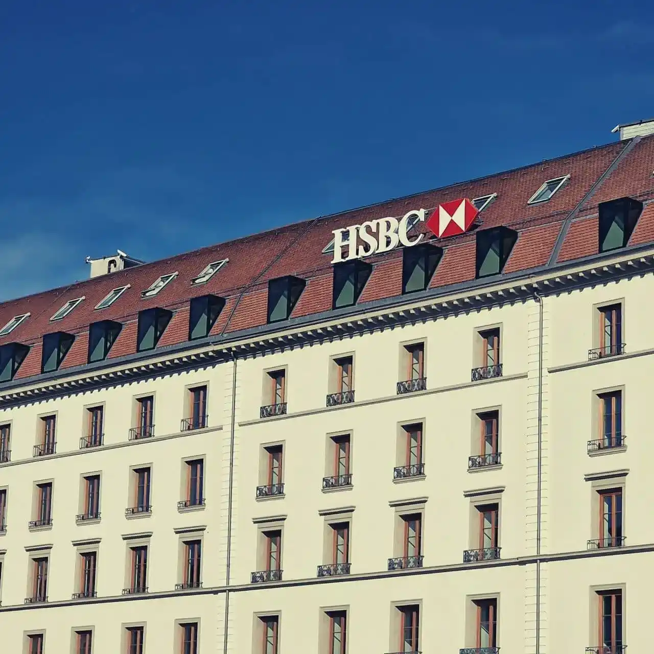 Façade d'un immeuble avec de nombreuses fenêtres et le logo HSBC sur le toit.