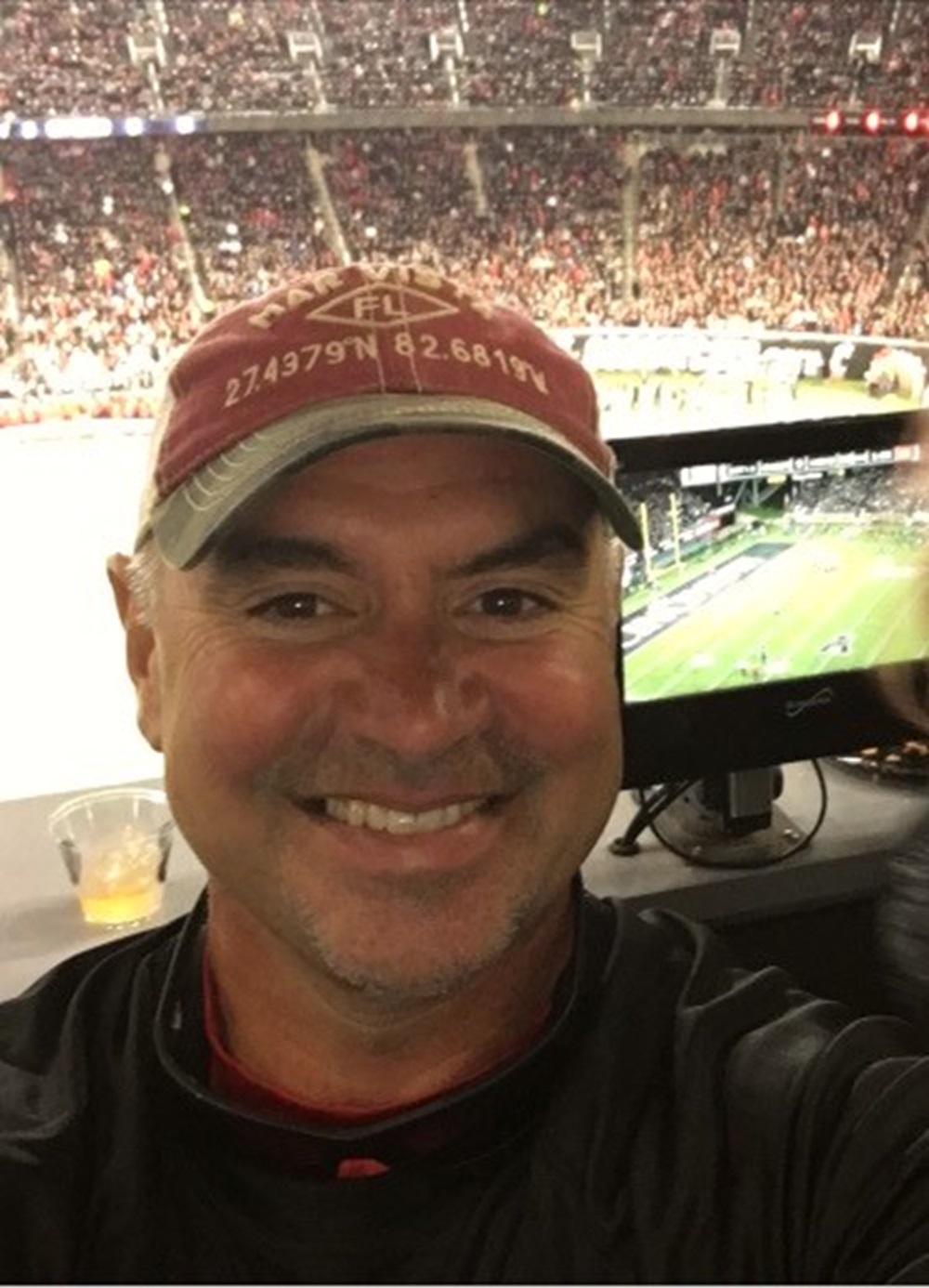 Elliott Allan Hilsinger smiling near stadium seating with spectators behind