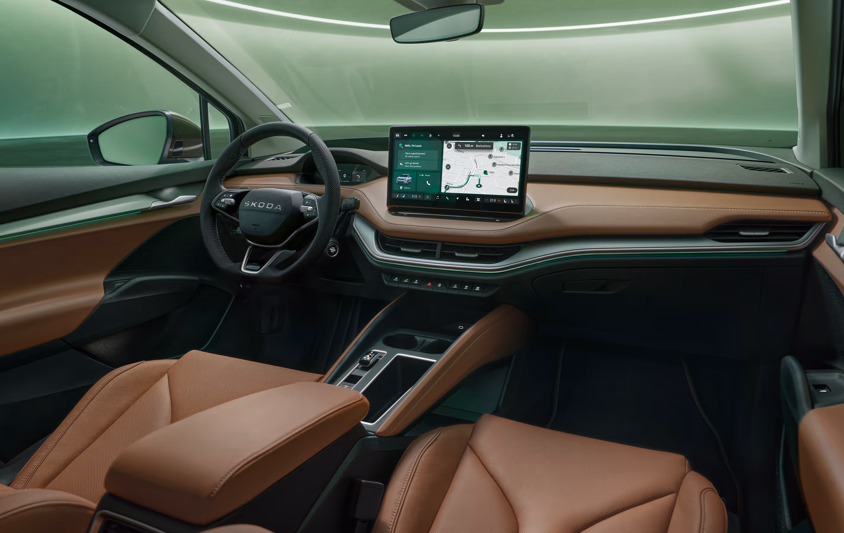 Innenansicht des Cockpits des Škoda Enyaq. Das Interieur ist mit braunem Leder und dunklen Materialien gestaltet. In der Mitte des Armaturenbretts befindet sich ein großer Infotainment-Bildschirm, der eine Navigationskarte anzeigt. Im unteren rechten Bildbereich steht auf einer dunkelgrün abgesetzten Fläche der Schriftzug „Smarte Details“.