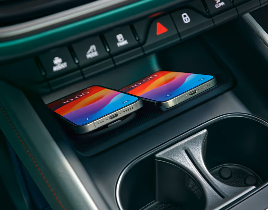 Nahaufnahme der Phone Box in der Mittelkonsole des Škoda Enyaq. Zwei Smartphones liegen nebeneinander und werden induktiv (kabellos) geladen.