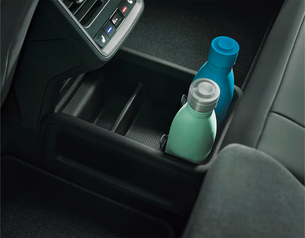 Detailansicht der Ablagebox im Mitteltunnel des Škoda Enyaq. In der Box stehen zwei Theromosflaschen, eine mint-grüne mit silbernem Deckel, die andere komplett aquamarin-blau.